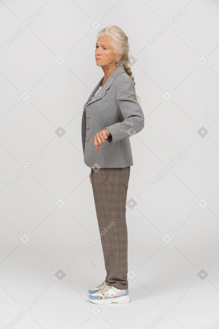 Side view of an old lady in suit showing thumb down