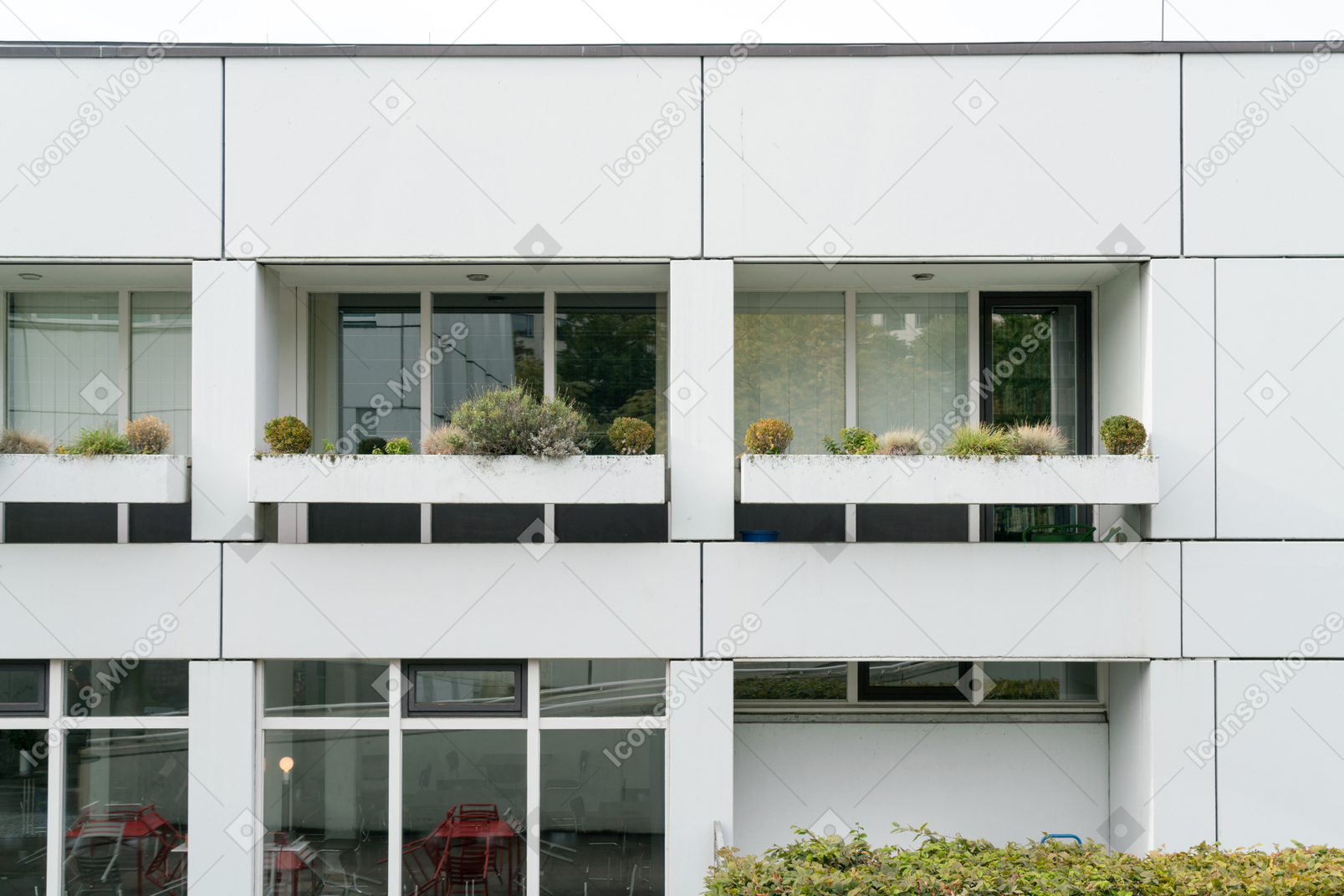 White office building with plants on the balcony
