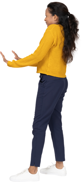 Vista lateral de uma garota assustada com roupas casuais mostrando um gesto de pare