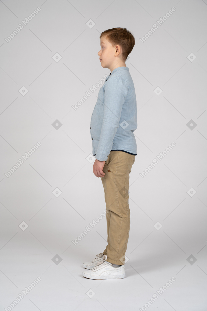 Boy in casual clothes standing in profile
