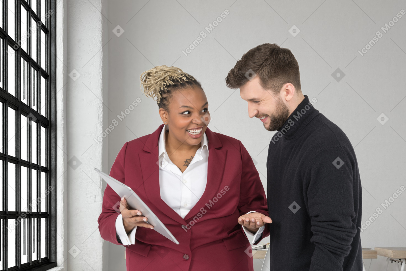 A woman with tablet and a man are laughing