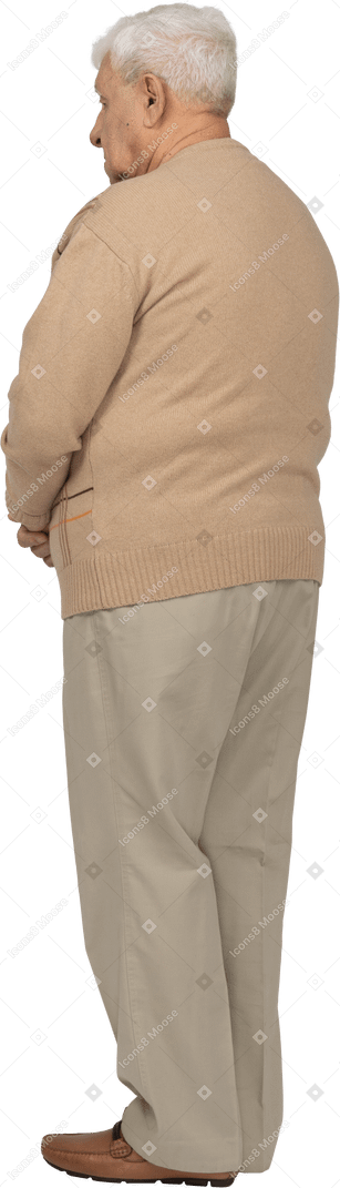じっと立っているカジュアルな服装の老人の背面図