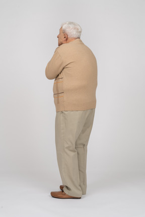 自分を窒息させるカジュアルな服装の老人の側面図