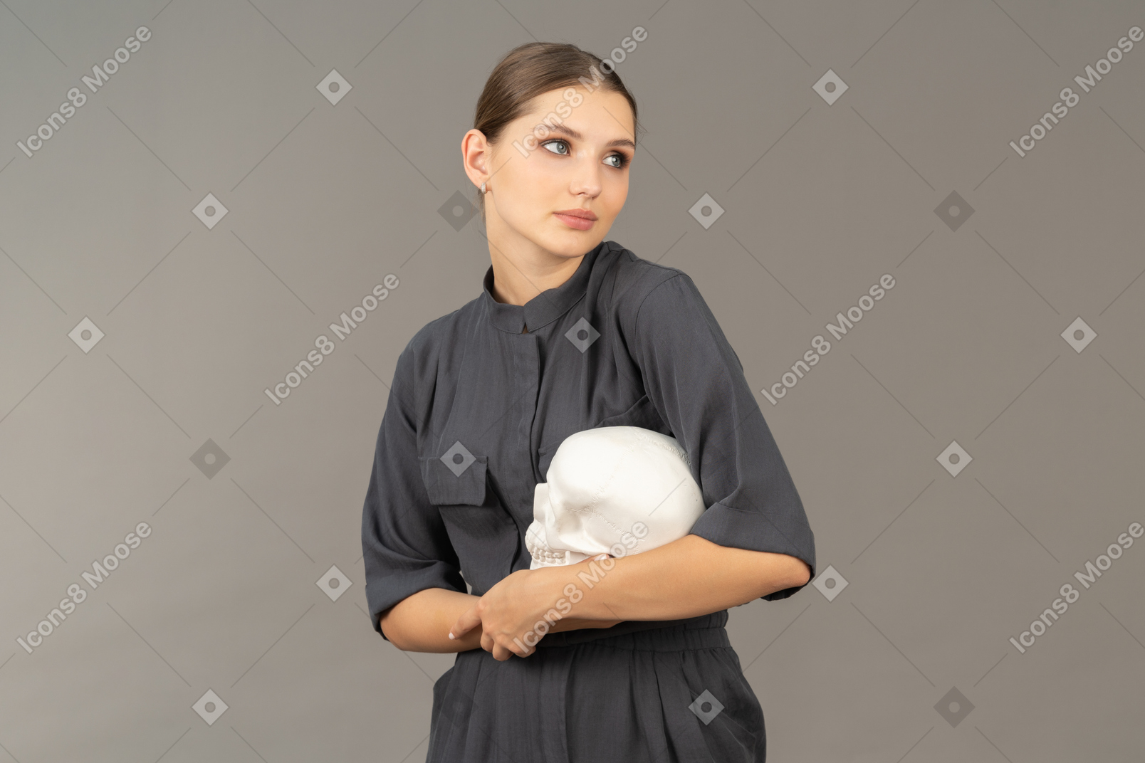 Вид спереди молодой женщины в комбинезоне с гипсовым черепом