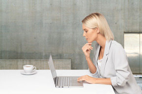 A woman sitting at a table using a laptop computer