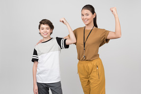 Pe maestra y alumna mostrando sus bíceps.