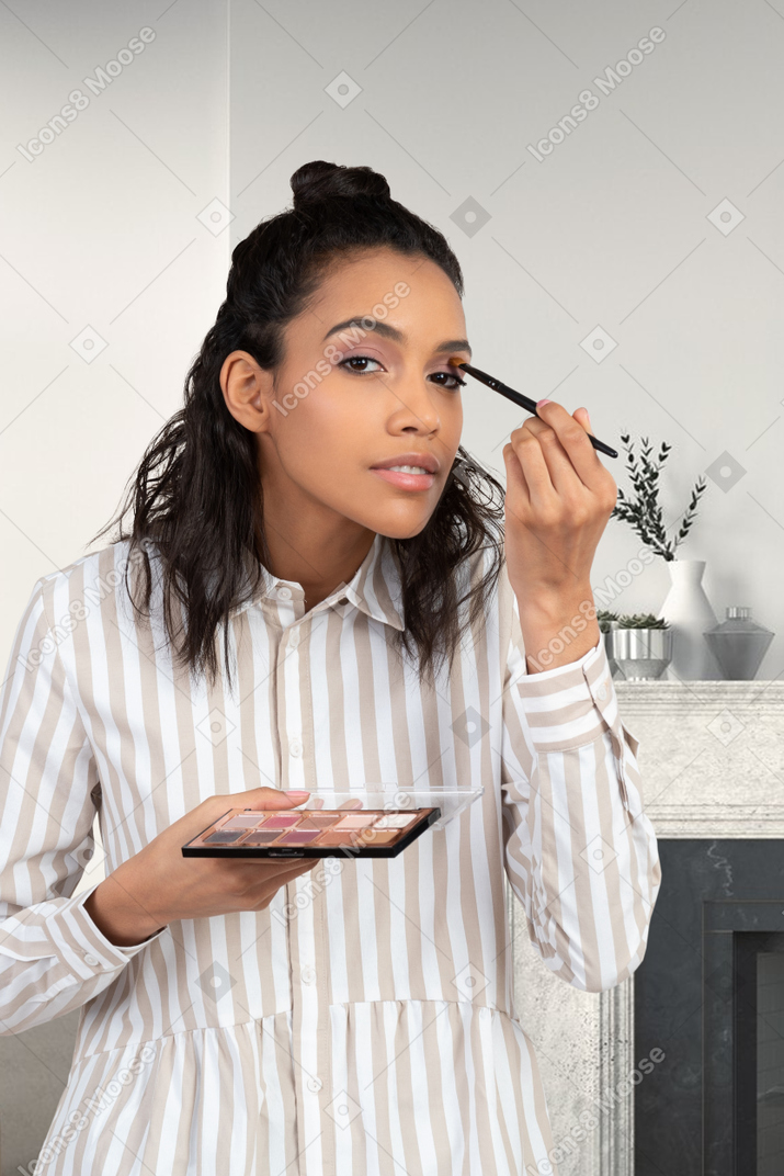 Woman applying eye shadow with makeup brush