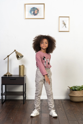 Cute girl kid posing on the apartments background