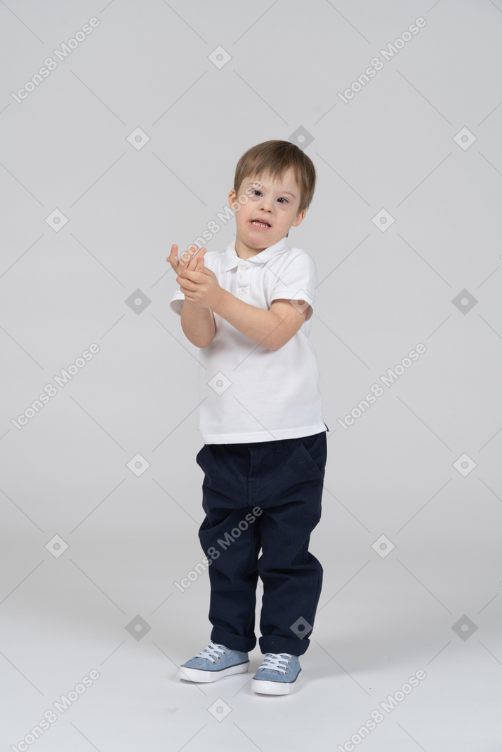 Vorderansicht eines kleinen jungen, der seine hände hochhält