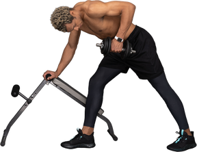 Side view of a shirtless afro man lifting the dumbbell