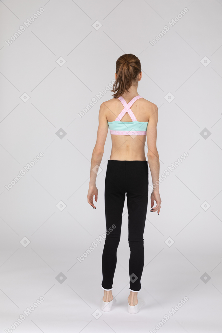 Vista posterior de una jovencita en ropa deportiva inmóvil
