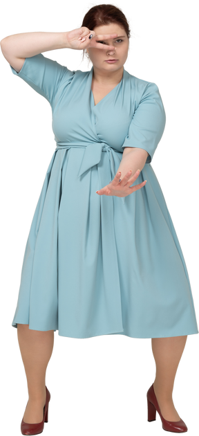 Front view of a woman in blue dress showing v sign