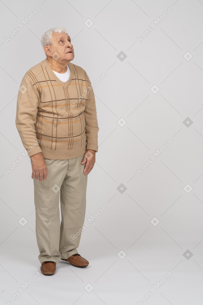 Vista frontal de um velho em roupas casuais, olhando para cima