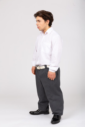 Вид в три четверти на мужчину в деловой повседневной одежде, отводящего взгляд
