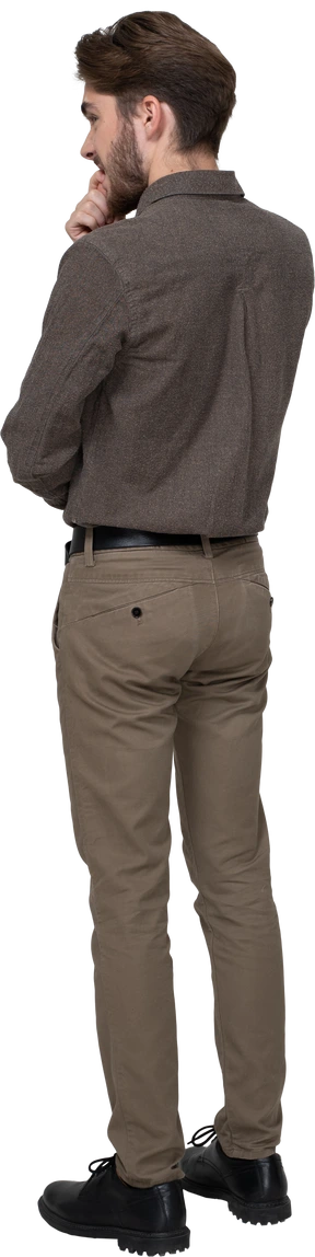 Three-quarter back view of a nervous young man in office clothing touching chin