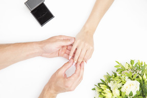 Male hand putting a ring on female hand
