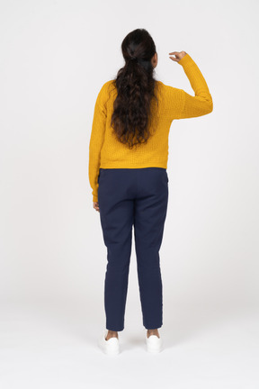 Vista posteriore di una ragazza in abiti casual che mostra le dimensioni di qualcosa