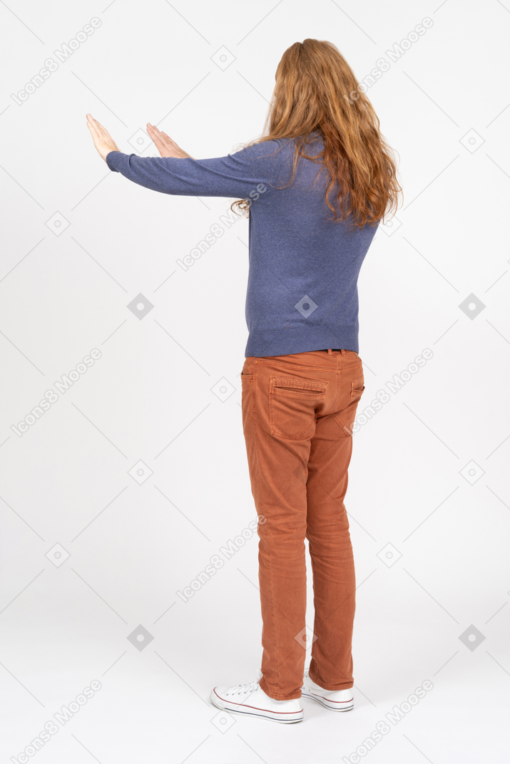 Vista laterale di un giovane in abiti casual in piedi con le braccia tese