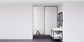 Badezimmer mit weißen wänden und schwarzem boden