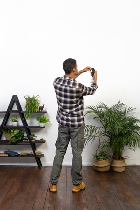 Three-quarter back view of a tourist examining a compass