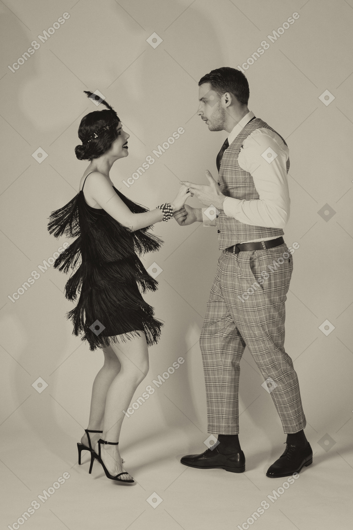 Retro-styled couple performing charleston dance