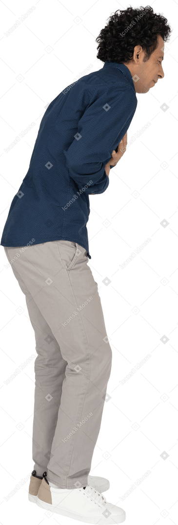 Vista laterale di un uomo in abiti casual che soffre di mal di stomaco
