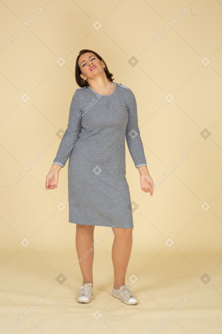 一个穿着灰色连衣裙的女人做鬼脸的前视图