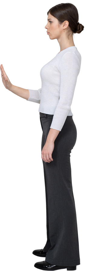 Vista lateral de una mujer joven en ropa de oficina extendiendo la mano
