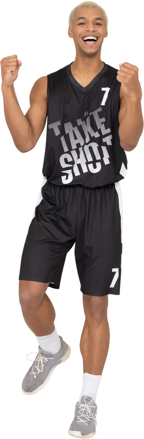 Vista frontal de um jovem jogador de basquete masculino feliz levantando as mãos