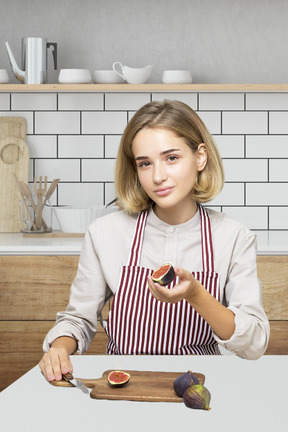 Pretty blonde at the table cutting fruits