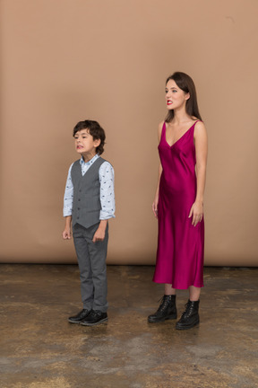 赤いドレスと男の子の若い女性の側面図