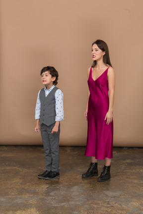 Side view of a young woman in red dress and boy