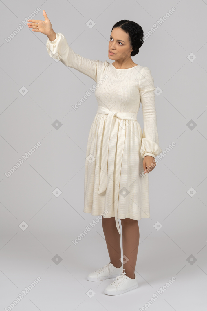 Serious young woman pointing aside with hand