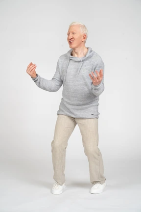 Three-quarter view of a man standing and holding hands up