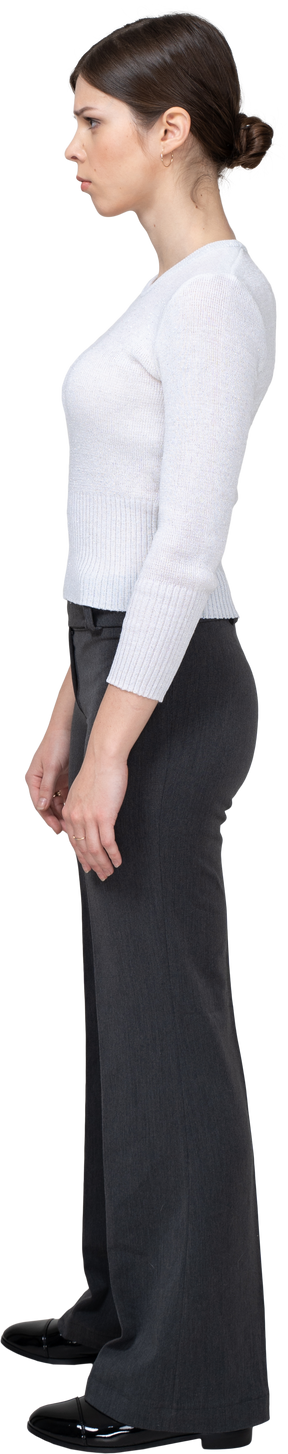 Vista laterale di una giovane donna in abiti da ufficio in piedi ancora e sopracciglia lavorate a maglia