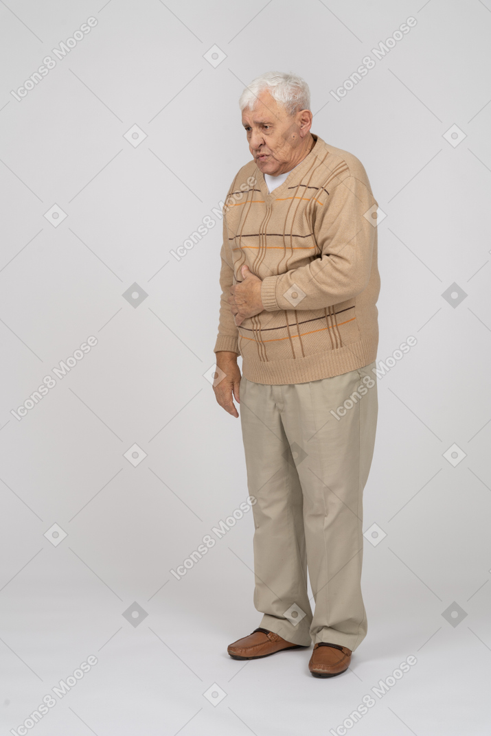 Front view of an old man suffering from stomachache
