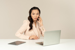 Empregado de escritório asiático envolvido em conversa telefônica