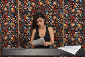 Serious young woman looking through a musical notation