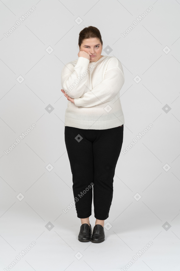 Front view of a tired plump woman in casual clothes looking at camera