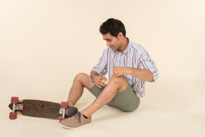 Young caucasian guy holding skate