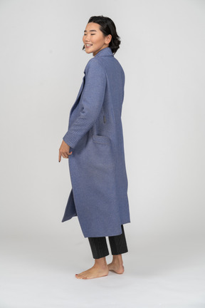 Back view of a smiling woman in coat