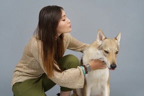 Primo piano di un maestro femmina che stringe a sé il suo cane