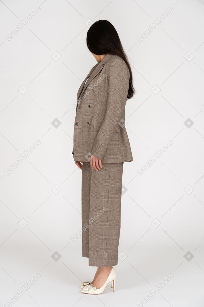 Side view of a young lady in brown business suit turning away