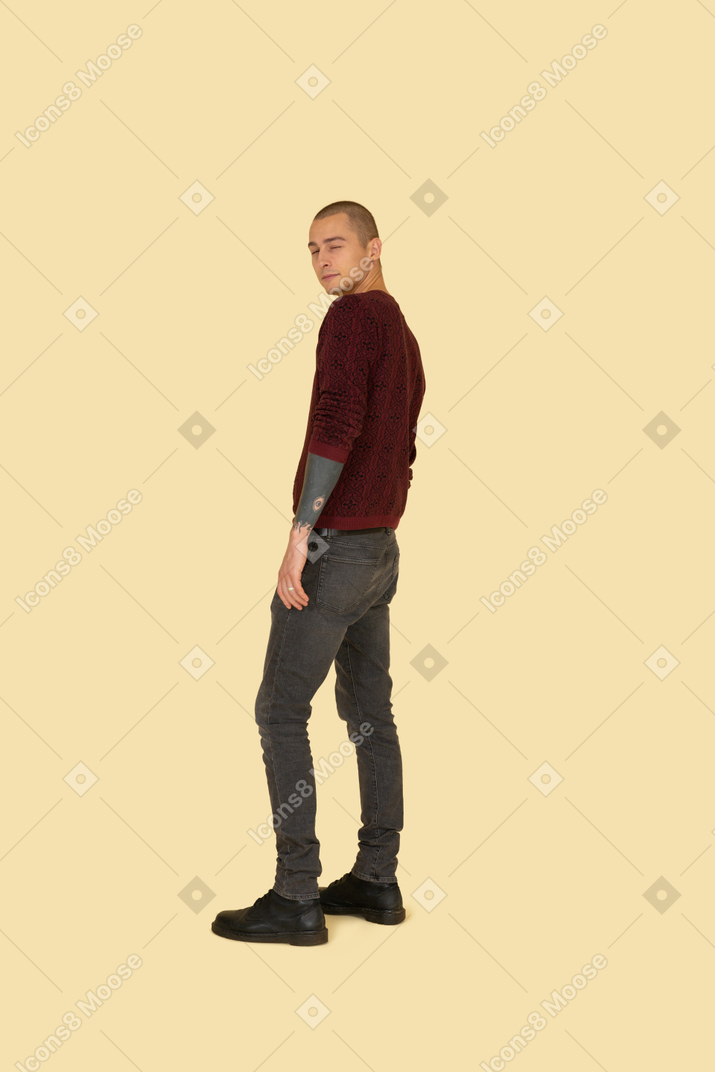 Vue latérale d'un jeune homme dans un pull rouge