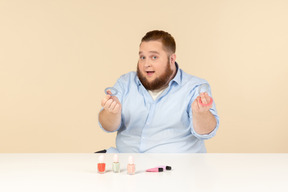 Big man looking attentively at hair bands he's holding