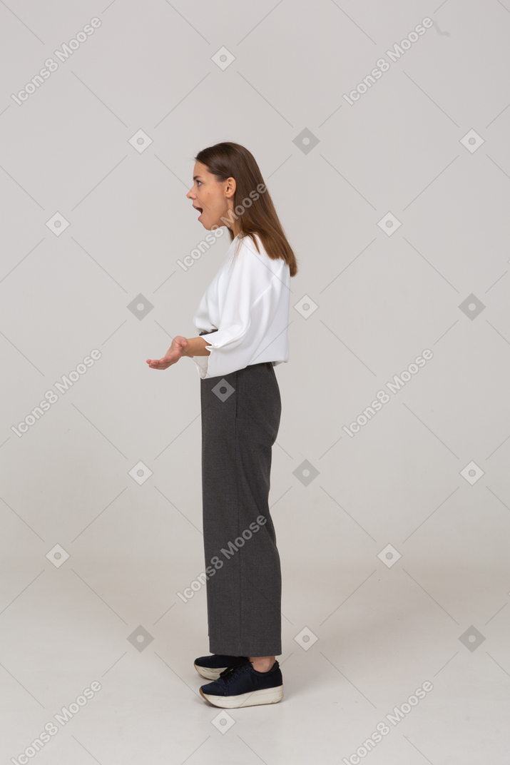 Side view of a wondering young lady in office clothing outspreading hands
