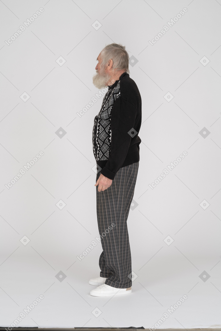 Vista lateral do homem idoso com barba grisalha em pé