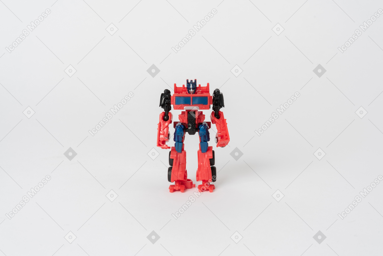 A toy transformer figure of red and black colours standing against a plain white background