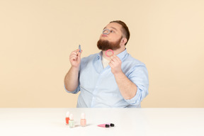 Big man sitting at the table and holding hair bands