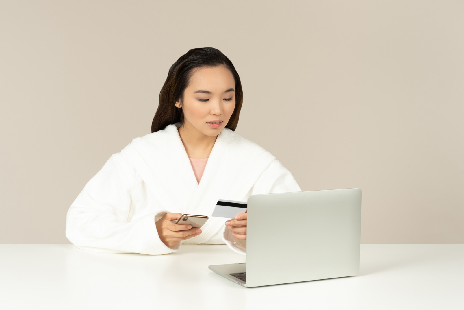 Young asian woman using phone and checking card